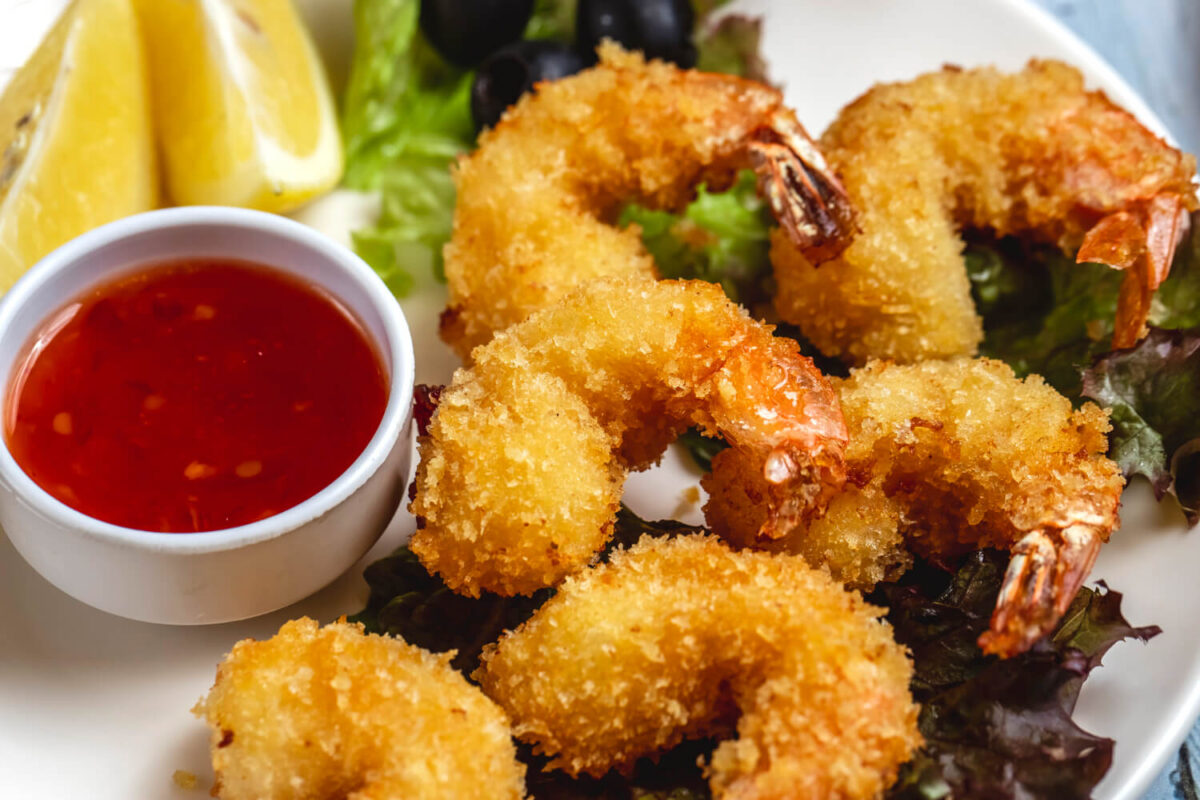 Golden fried shrimp with crispy coating served with sweet chili sauce and fresh lemon wedges.